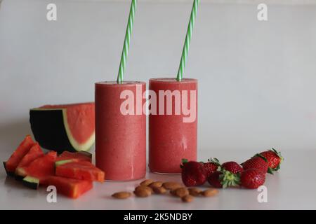 Smoothie fraise pastèque. Boisson d'été faite de pastèque et de fraises fraîches dans du lait d'amande. Prise de vue sur fond blanc avec pastèque Banque D'Images