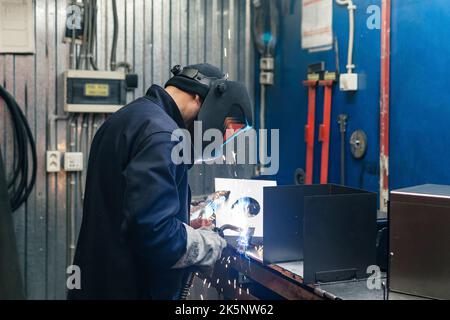 Perm, Russie - 21 septembre 2022 : soudeur au travail, soudeur de pièces métalliques en atelier Banque D'Images