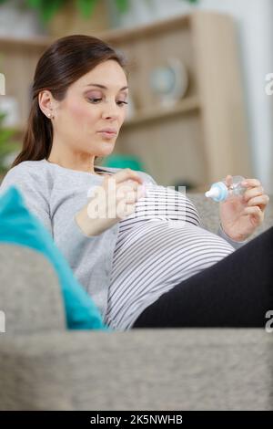 femme enceinte sur son canapé Banque D'Images