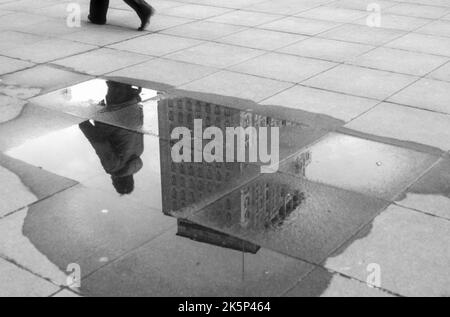 Photographie d'archives en noir et blanc de 1982 du Shell Center reflétée dans une flaque sur la South Bank de Londres. Banque D'Images