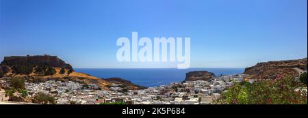 Vue panoramique sur le port coloré du village de Lindos et de l'Acropole, Rhodes. Vue aérienne du paysage magnifique, des ruines antiques, de la mer avec des voiliers et de la côte de l'île de Rhodes en mer Egée Banque D'Images