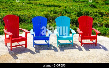 Chaises Adirondack colorées près d'un jardin en Nouvelle-Écosse, au Canada Banque D'Images