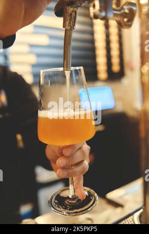 Main de barman versant une grande bière lager dans le robinet. Verser de la bière pour le client. Mise au point sélective. Heure du week-end Banque D'Images