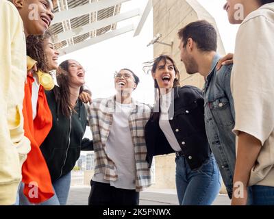 Groupe d'amis divers qui s'embrasent et rient tout en ayant un bon moment ensemble. Meilleurs amis Banque D'Images