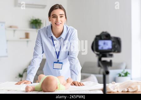 Jeune femme avec peu d'enregistrement de bébé cours vidéo à la maison Banque D'Images