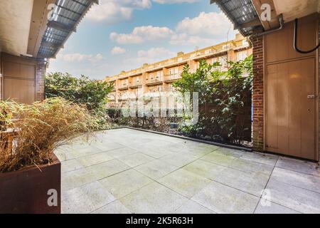 Beau patio pavé avec un petit jardin près d'une clôture en bois Banque D'Images