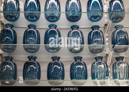 Etagère sur un mur blanc avec des bouteilles bleues dans le magasin. Vases bleus sur la tablette du magasin. Personne, attention sélective Banque D'Images