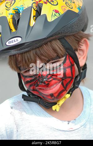 Kid biker avec peinture sur visage à session de formation par les agents de police Banque D'Images