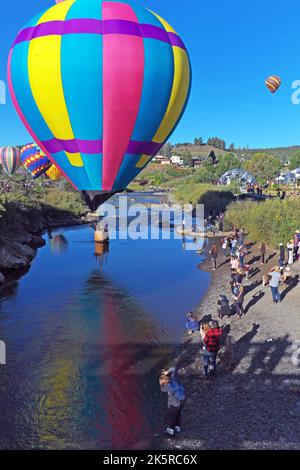 Une montgolfière survole la rivière San Juan dans le centre-ville de Pagosa Springs, Colorado, lors du rallye annuel de montgolfières Colorfest sur 17 septembre 2022. Banque D'Images