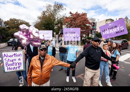 Washington, États-Unis. 08th octobre 2022. Un petit groupe de contre-manifestants anti-avortement se tiennent derrière leurs gardes de sécurité privés lors de la Marche des femmes pour les droits génésiques, l'accès à l'avortement et l'autonomie corporelle à Washington. Il s'agissait de l'événement phare d'une manifestation nationale de la « vague des femmes » dans des centaines de villes des États-Unis. La Marche des femmes a organisé les manifestations en réponse à l'avis Dobbs c. JWHO de la Cour suprême, qui a renversé Roe c. Wade, éliminant le droit fédéral à l'avortement. Crédit : SOPA Images Limited/Alamy Live News Banque D'Images