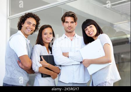 C'est ce qu'il faut. Un groupe de jeunes entrepreneurs prospères qui se tiennent en ligne ensemble. Banque D'Images