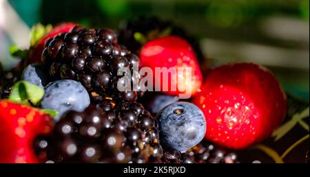 Gros plan baies en hauteur gros plan mélange coloré de fraises, de bleuets, de mûres et de cassis Banque D'Images