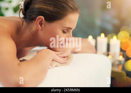 Perdez votre temps sagement. Une belle jeune femme allongé sur une table de massage au spa. Banque D'Images