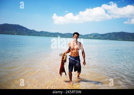 En arrivant d'une journée de travail. Bateau traditionnel thaïlandais à longue queue sur la plage - Thaïlande. Banque D'Images