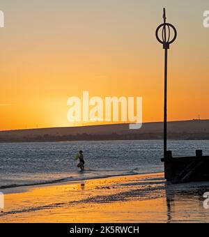 Portobello, Édimbourg, Écosse, Royaume-Uni. 10th octobre 2022. Lever de soleil frais à 9 degrés centigrade pour ceux qui s'aventurer en bord de mer pour faire de l'exercice ou simplement se baigner dans la lumière de l'aube. Une femme se dirige vers le Firth of Forth pour un plongeon froid. Crédit : Arch White/alamy Live News. Banque D'Images