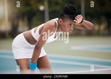 Joueur de tennis concentré essuyant la transpiration de sa tête. Un athlète fait une pause après un match de tennis. Un jeune joueur de tennis se reposant après un match de tennis Banque D'Images