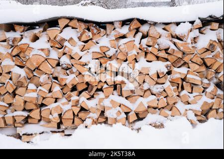 bois de chauffage texturé fond bois haché pour l'allumage et le chauffage. pile de bois avec bois de chauffage empilé bouleau arbre recouvert de neige fraîche glacée gelée et de neige Banque D'Images