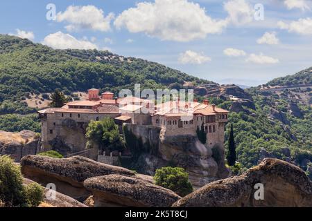 Toits de tuiles rouges, cheminées et fenêtres voûtées ornementées de bâtiments religieux médiévaux du monastère Saint-Varlaam à Meteora, Grèce Banque D'Images