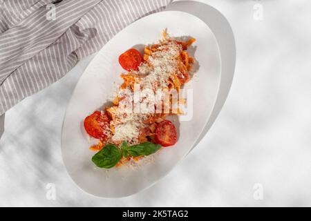 Bucatini maison, pâtes Amatriciana avec bacon, tomates cerises et parmesan sur fond blanc pour le menu du restaurant. Banque D'Images