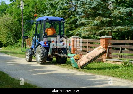 petit tracteur municipal appartenant aux autorités locales utilisé pour couper des pelouses dans la voie rurale du petit hameau du comté de zala en hongrie Banque D'Images