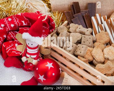 Boîte de Noël en forme de chien dans un cadre de fête rustique avec cloches de jingle Banque D'Images