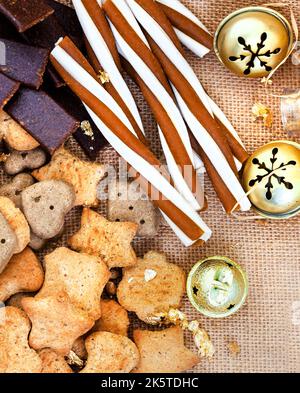 Boîte de Noël en forme de chien dans un cadre de fête rustique avec cloches de jingle Banque D'Images