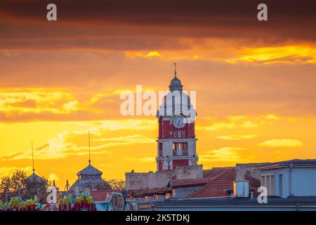 Ancienne tour horloge de la gare de Varna, Bulgarie et oiseaux volants au coucher du soleil Banque D'Images