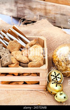 Boîte de Noël en forme de chien dans un cadre de fête rustique avec cloches de jingle Banque D'Images