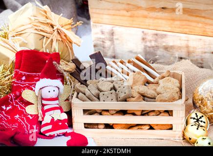 Boîte de Noël en forme de chien dans un cadre de fête rustique avec cloches de jingle Banque D'Images