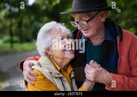 Portrait d'un couple aîné amoureux à la promenade dans le parc de la ville. Banque D'Images