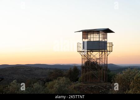 Tour de guet pour la surveillance des incendies en silhouette au sommet d'une colline surplombant la campagne au lever du soleil dans l'Alentejo Portugal Banque D'Images