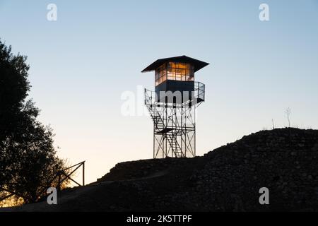 Tour de guet pour la surveillance des incendies en silhouette au sommet d'une colline surplombant la campagne au lever du soleil dans l'Alentejo Portugal Banque D'Images