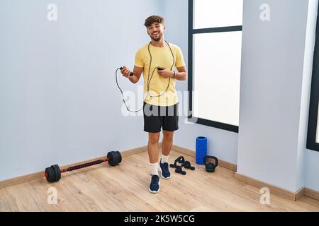 Homme arabe avec formation de barbe avec corde de saut sourire et riant dur dehors fort parce que drôle de blague fou. Banque D'Images
