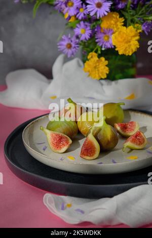 Figues fruits placés sur une petite assiette sur une table avec une nappe et le soleil Banque D'Images