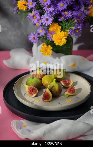 Figues fruits placés sur une petite assiette sur une table avec une nappe et le soleil Banque D'Images