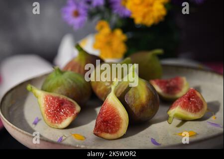 Figues fruits placés sur une petite assiette sur une table avec une nappe et le soleil Banque D'Images