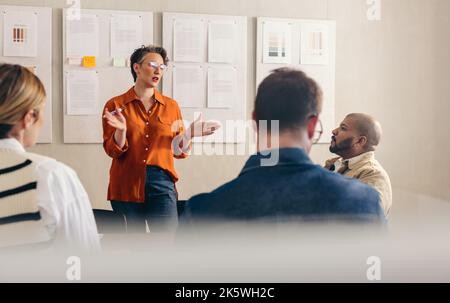 Une femme d'affaires mûre en train de lui faire part de son idée lors d'une réunion. Chef d'équipe mature discutant de sa stratégie avec ses collègues. Groupe d'affaires Banque D'Images