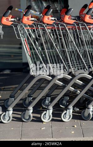 Image symbolique: Shopping dans un supermarché: Les chariots poussés ensemble Banque D'Images