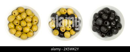 Olives vertes et noires dénoyautées, Hojiblanca, dans des bols blancs, d'en haut. Olives européennes, Olea europaea, cultivar de Lucena, Espagne. Banque D'Images