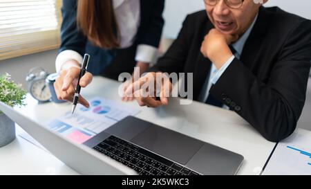 Concept de partenariat d'affaires, Business senior et femme d'affaires pointent les données sur l'ordinateur portable et discutent. Banque D'Images