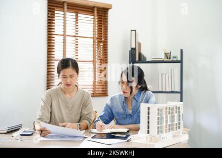 Concept de construction d'ingénierie, deux femmes ingénieurs discutent de construction et prennent des notes. Banque D'Images