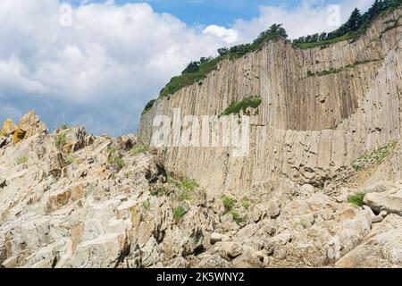 Haute falaise côtière formée par des colonnes de pierres de lave solidifiées, cap Stolbchaty sur l'île de Kunashir Banque D'Images