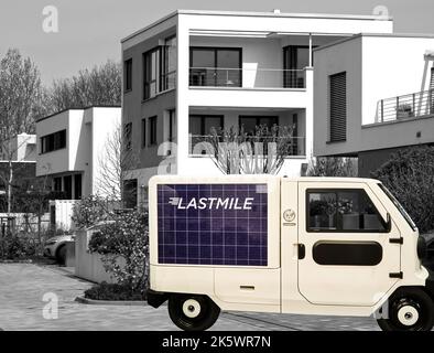 XBus S, minibus électrique pour le transport de petites marchandises aux consommateurs de la ville, composite devant les maisons d'appartements cubiques minimalistes, Banque D'Images