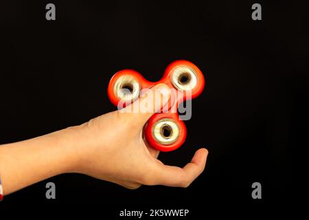 Jeu de main d'enfant avec un jouet de spinner de violon Banque D'Images