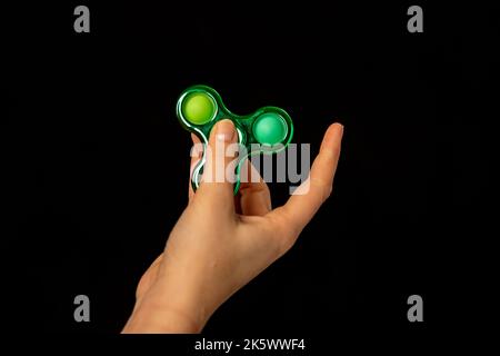 Jeu de main d'enfant avec un jouet de spinner de violon Banque D'Images