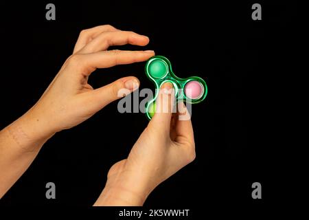 Jeu de main d'enfant avec un jouet de spinner de violon Banque D'Images