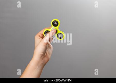 Jeu de main d'enfant avec un jouet de spinner de violon Banque D'Images