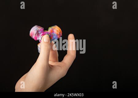 Jeu de main d'enfant avec un jouet de spinner de violon Banque D'Images