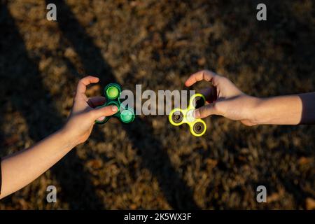 Jeu de main d'enfant avec un jouet de spinner de violon Banque D'Images