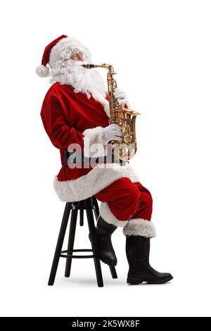 Le Père noël assis sur une chaise et jouant un saxophone isolé sur fond blanc Banque D'Images